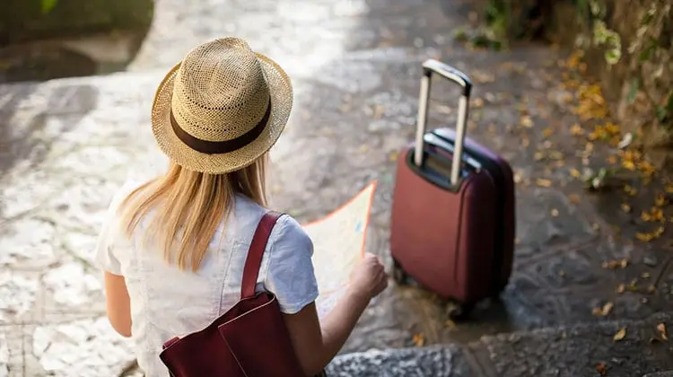 Viajante sentada repassando o que não pode esquecer numa viagem a Europa