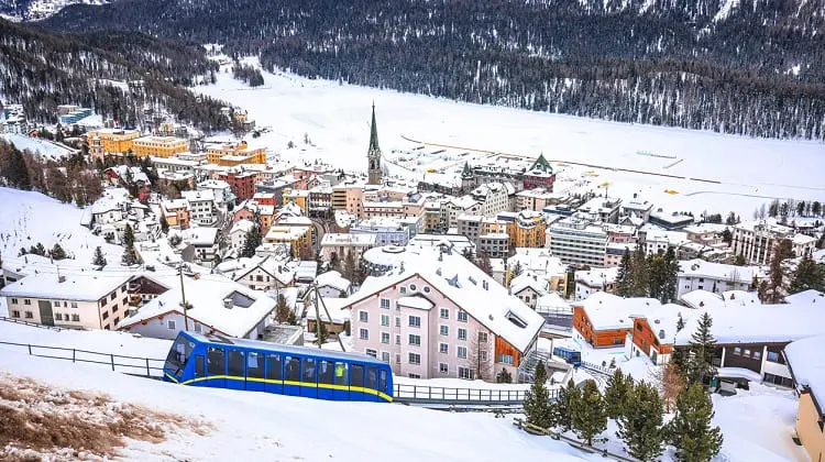 Vista da cidade de St. Moritz embaixo de neve e o lago congelado