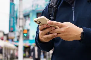 homem segura celular na rua durante viagem