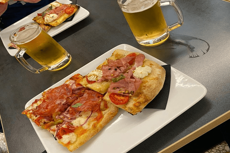 Fatias de pizza e copos de cerveja
