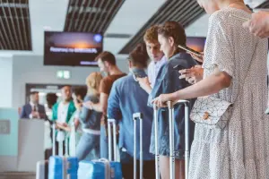 Passageiros na fila após overbooking garantindo seus direitos.