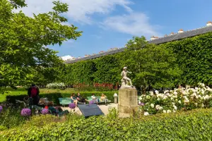 Pessoas em jardim parisiense.