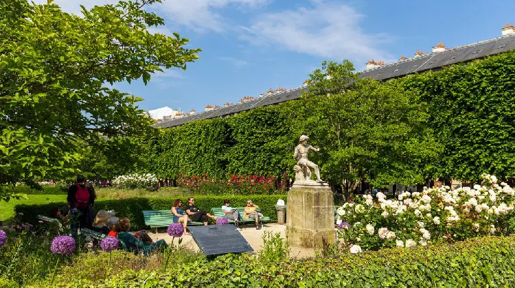 Pessoas em jardim parisiense.