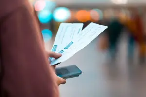 Mulher segurando passagens aéreas para Roma na mão