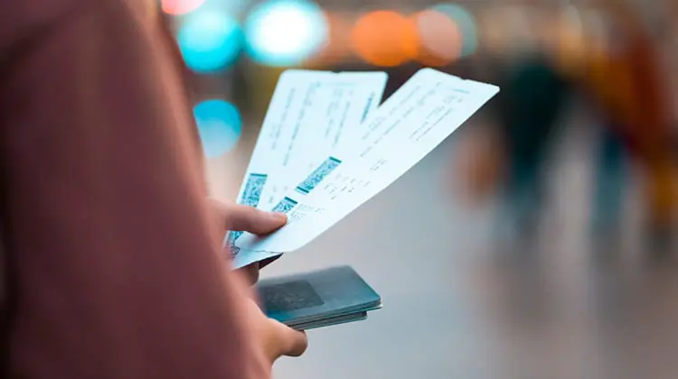 Mulher segurando passagens aéreas para Roma na mão