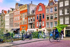 Mulher de bicicleta atravessa uma ponte em Amsterdam