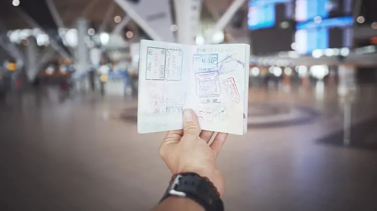 Mulher mostrando os carimbos em seu passaporte