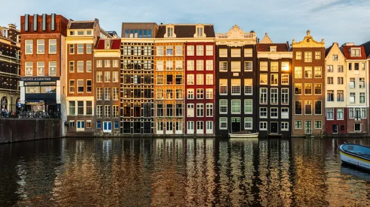 Casas típicas de Amsterdam em frente a um canal.