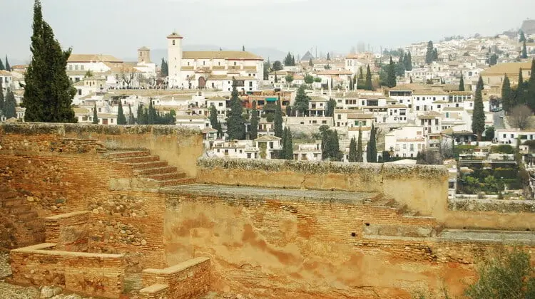 Cenário da cidade de Granada por trás de muralha da Alhambra