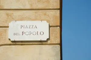 Parede com uma placa de uma praça em Roma
