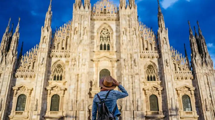 Mulher admirando a catedral de Milão em um dia de sol.