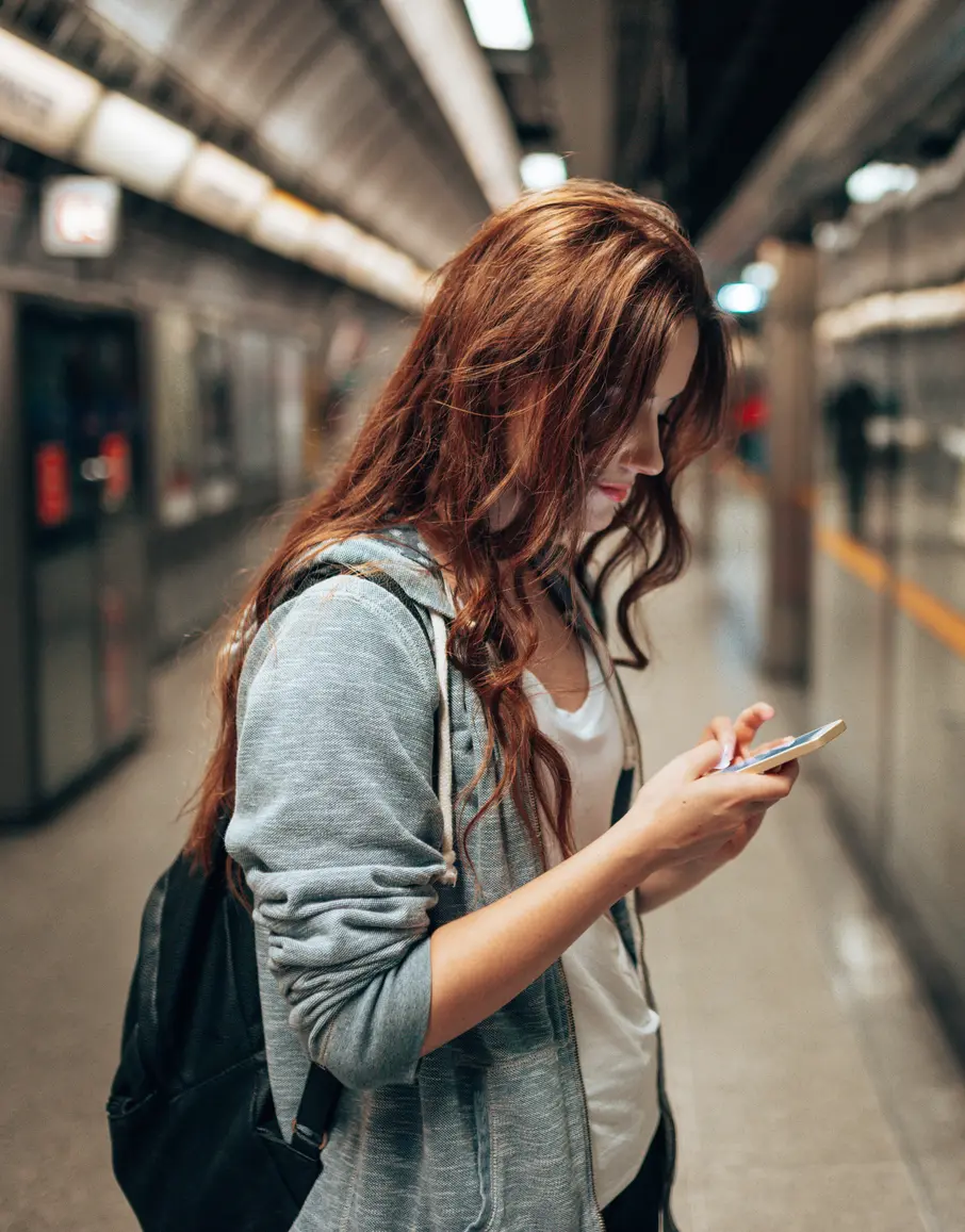 mulher usando o celular no metrô na Europa
