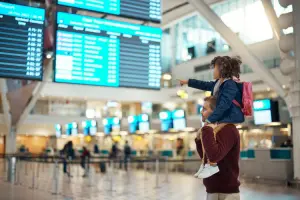 Criança nos ombros do pai dentro do aeroporto