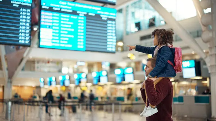 Criança nos ombros do pai dentro do aeroporto
