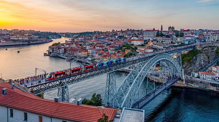 Transporte público e pedestres atravessando a Ponte Luís I, entre o Porto e Vila Nova de Gaia