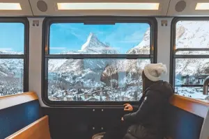 Turista mulher aproveita a vista da janela na viagem de trem mais longa do mundo
