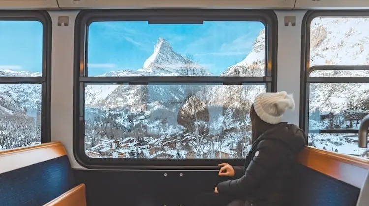 Turista mulher aproveita a vista da janela na viagem de trem mais longa do mundo