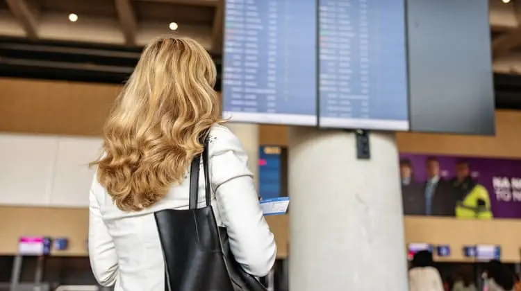 Passageira olhando para painel de voos