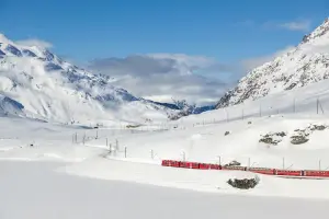 Vista do trem Bernina express repleta de neve, em dia de sol