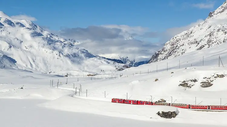 Vista do trem Bernina express repleta de neve, em dia de sol