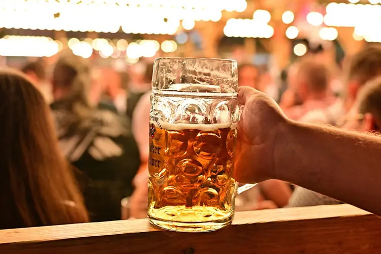 Mão segurando caneca de cerveja grande na Oktoberfest