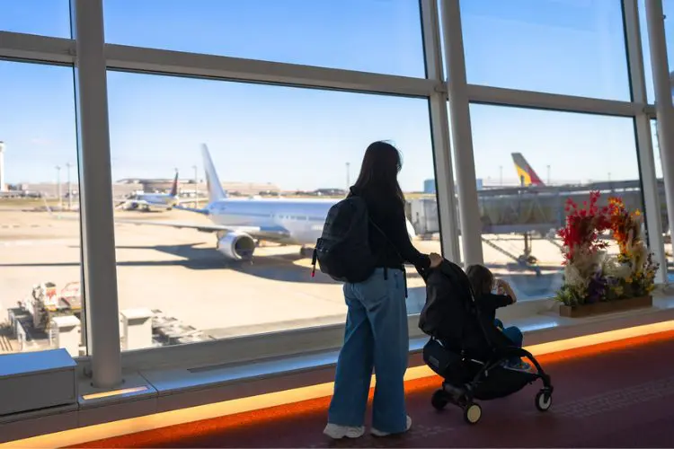 Mulher andando no aeroporto com carrinho de bebê