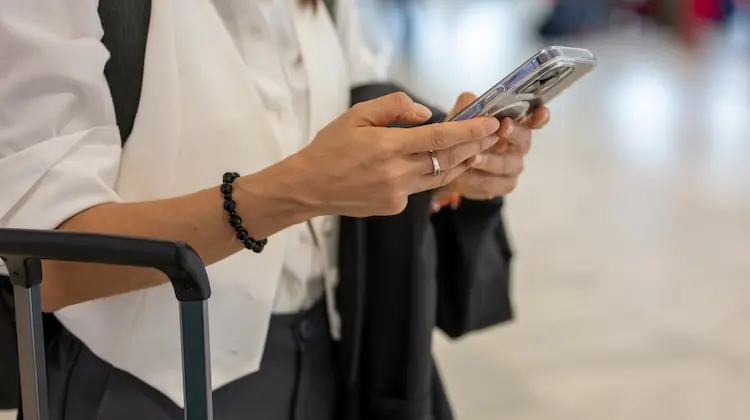 Mulher usa celular no aeroporto já conectada com chip de internet na Europa