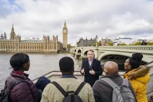 Guia turístico conversa com um grupo de viajantes em frente ao Big Ben e ao Parlamento de Londres, em um city tour em Londres