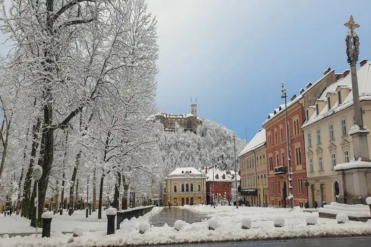 Praça do congresso com muita neve, em dia ensolarado e céu azul.