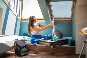 Mulher escolhendo o que levar na mala para Europa na primavera