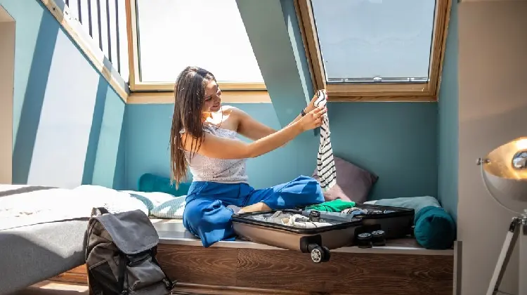 Mulher escolhendo o que levar na mala para Europa na primavera