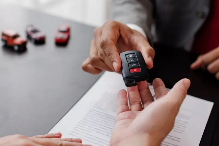 Pessoa recebendo chave de carro alugado