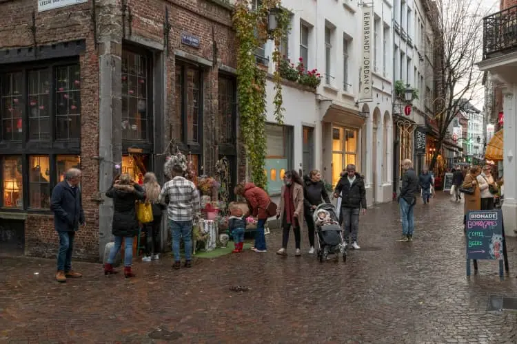 Pessoas com roupas de frio caminham por rua no centro da Antuérpia, na Bélgica