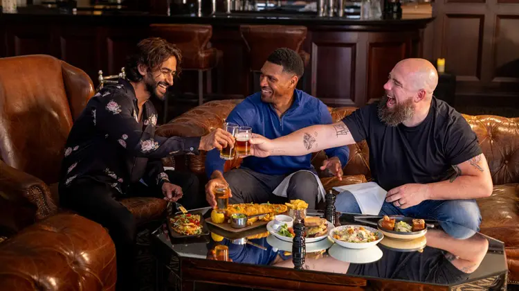 Grupo de amigos reunidos para almoço em tradicional pub irlandês.