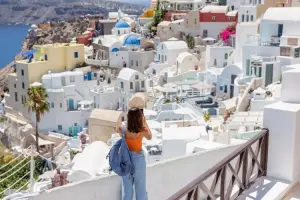 Turista apreciando a vista de Oia, em Santorini.