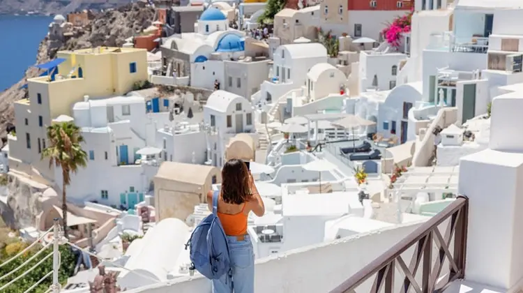 Turista apreciando a vista de Oia, em Santorini.