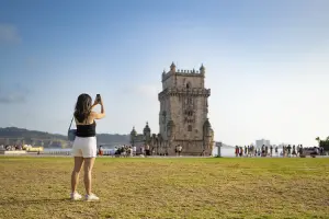 Mulher com seguro viagem, visita Torre de Belém, em Lisboa