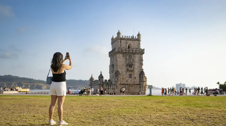 Mulher com seguro viagem, visita Torre de Belém, em Lisboa