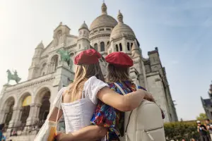Duas turistas com seguro viagem, olhando para Basílica de Sacré Coeur, em Paris