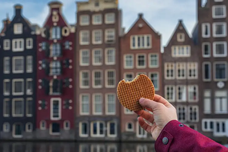 Mulher segurando um Stroopwafels, em dia nublado