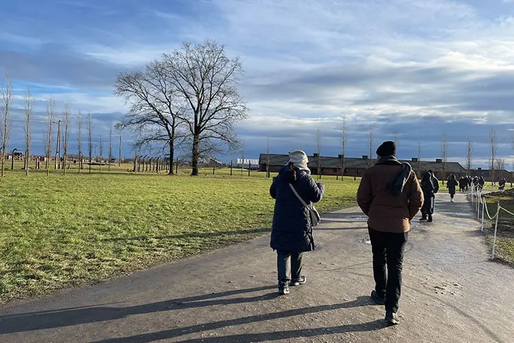 Duas pessoas caminhando pelo campo de Birkenau