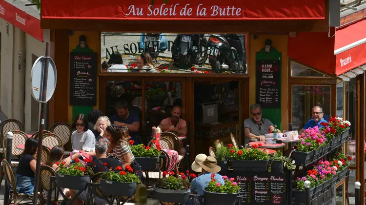 Típica fachada de bares em Paris, com mesinhas na calçada
