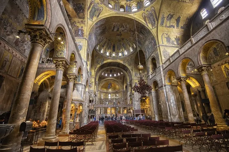 Interior da Basílica de São Marcos, igreja decorada com mosaicos dourados e vitrais coloridos