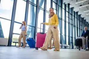 Viajantes com malas em aeroporto, exemplificando como Momondo é confiável para planejar viagens