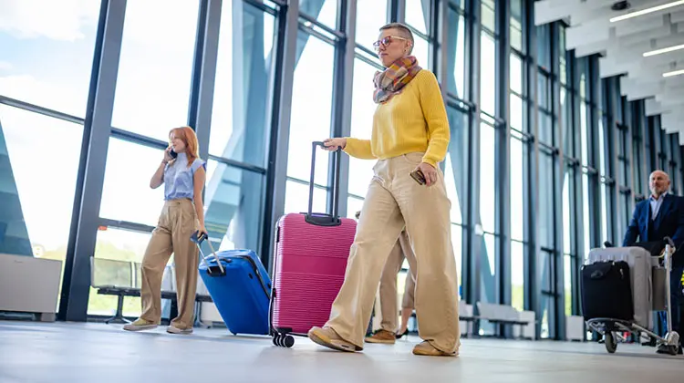 Viajantes com malas em aeroporto, exemplificando como Momondo é confiável para planejar viagens