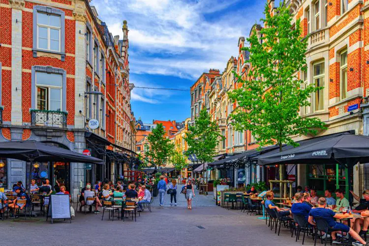 Cafés e restaurantes movimentados na parte antiga de Leuven, na Bélgica, em dia de verão