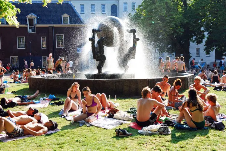 Pessoas tomando banho de sol no parque na Holanda