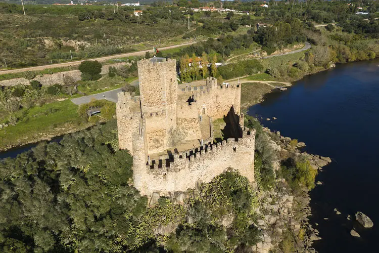 Castelo de Almourol visto a partir de drone num dia ensolarado e com vegetação ao fundo