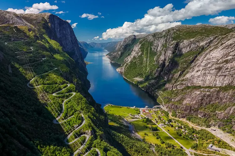 Vista panorâmica de Kjerag sobre o fiorde Lysebotn, em Lysefjorden, Noruega, com montanhas ao fundo, local perfeito para visitar a Europa em julho