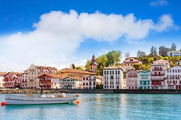 Vista da vila de Saint-Jean-de-Luz a partir do mar com barcos pesqueiros e casas coloridas